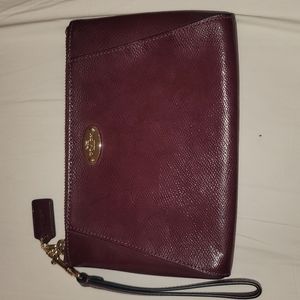 Mid-sized burgundy patent Coach wristlet.